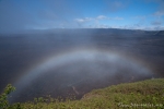 Der aufziehende Nebel formt sich zu einem Regenbogen über dem Kraterrand des