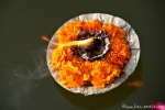 Blumenschälchen mit brennendem Docht treiben im Ganges